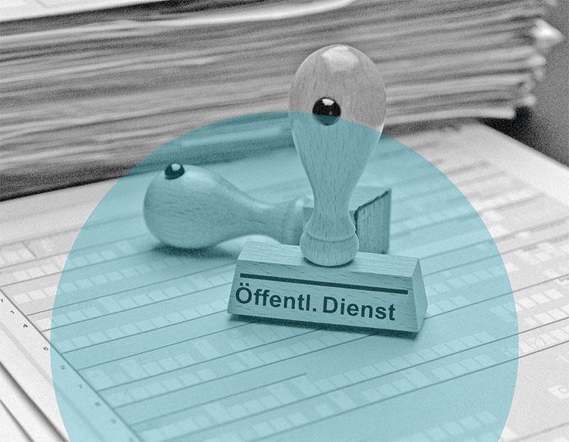 Ein Holzstempel mit der Aufschrift 'Öffentl. Dienst' liegt auf einem Formular – Symbolbild für den kognitiven Leistungstest für Verwaltungsberufe.